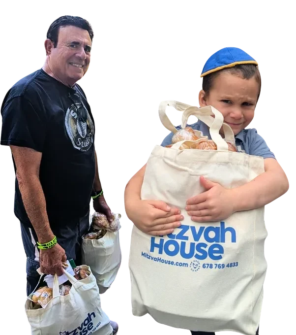 Two Mitzvah House volunteers, a man and a young boy, carrying bags of meals.